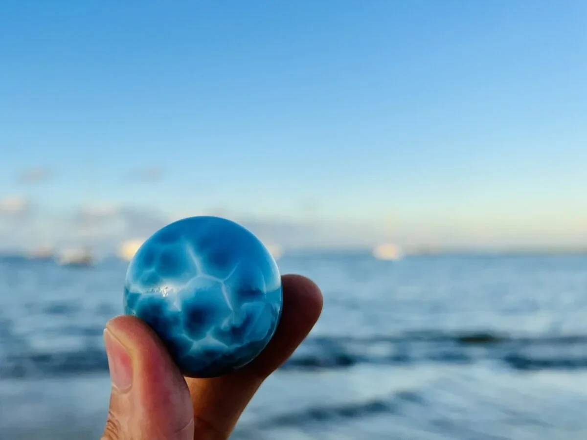 Ein poliertes blaues Larimar-Exemplar in einer Hand