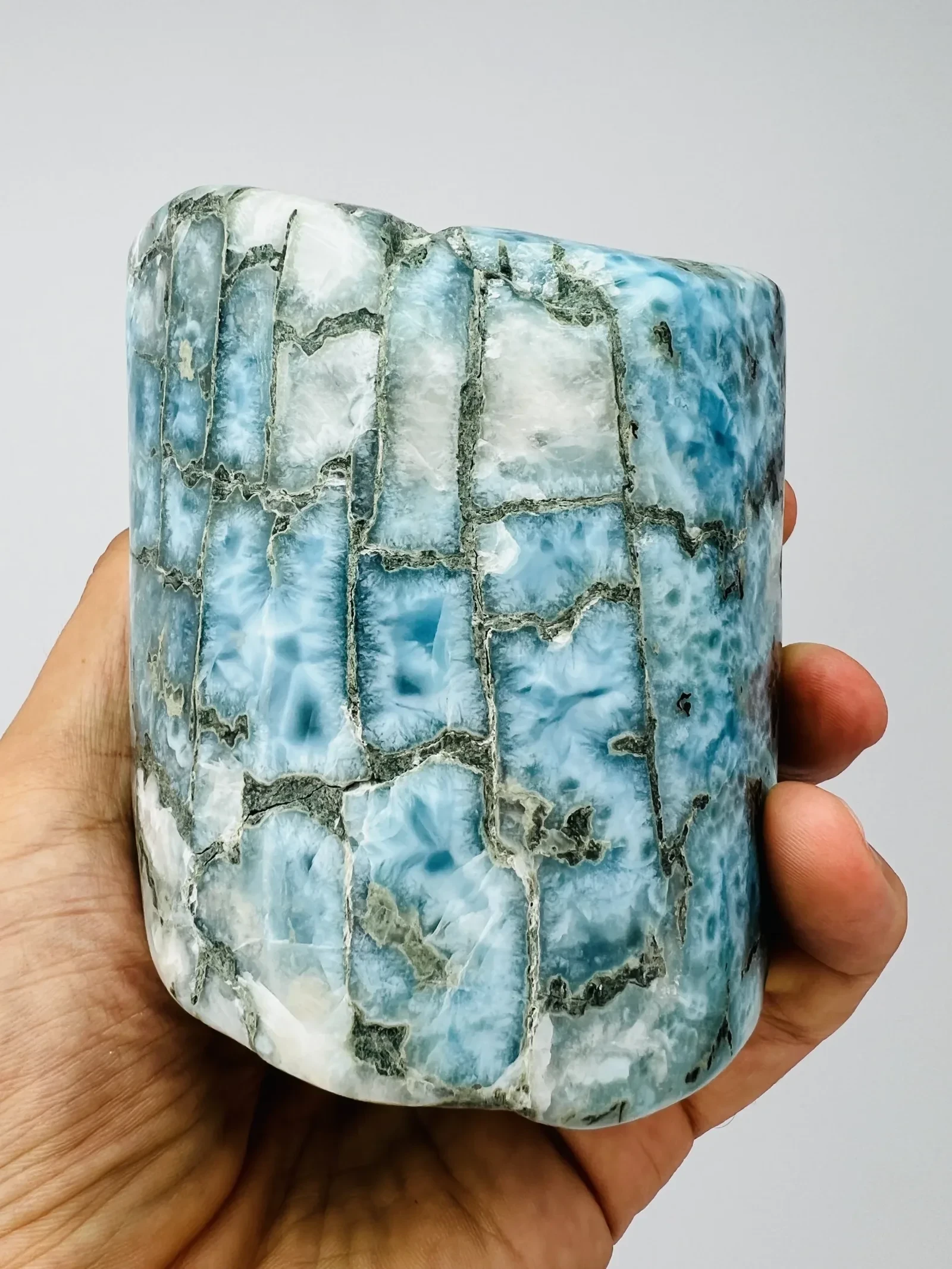 A large patterned Larimar statement piece held for scale.