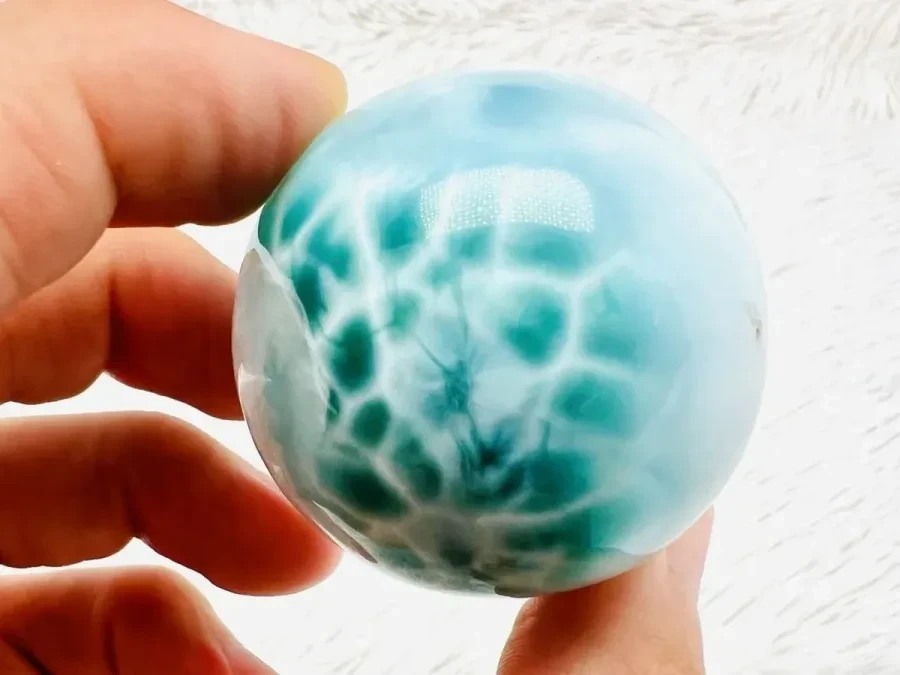 A Green Larimar sphere with blue, green and white patterning.