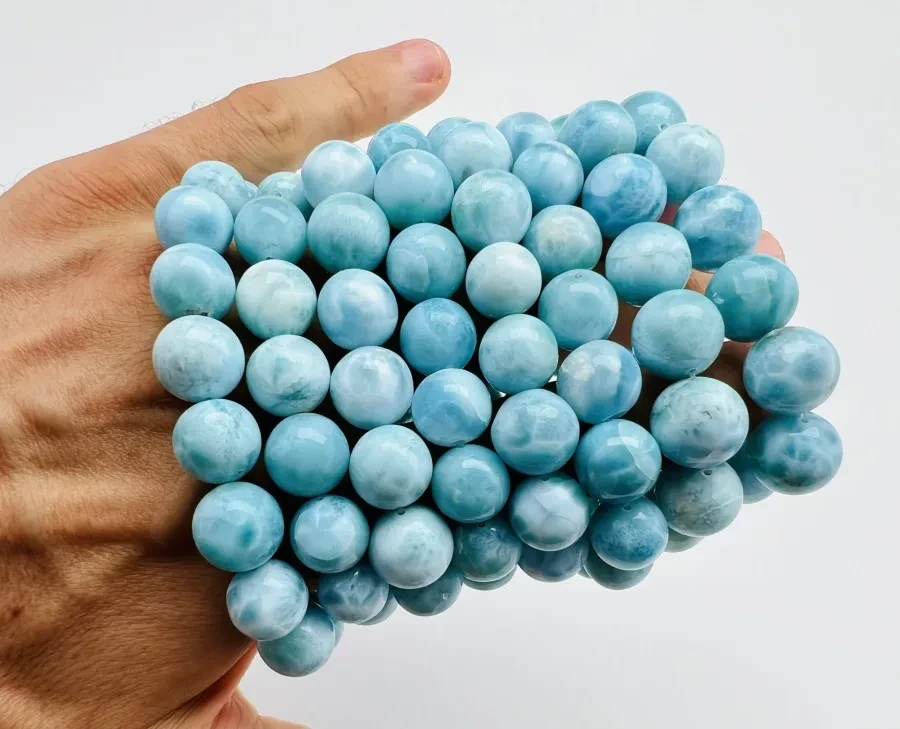 A handful of small polished Larimar spheres.