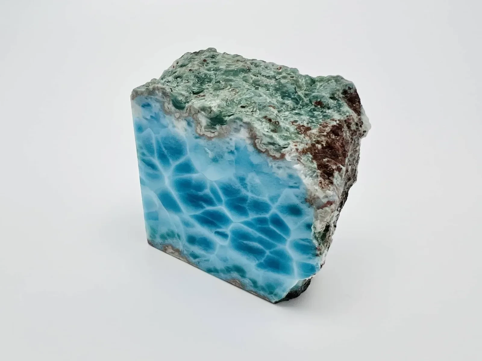 A Larimar specimen showing blue mineralization beside its host rock.