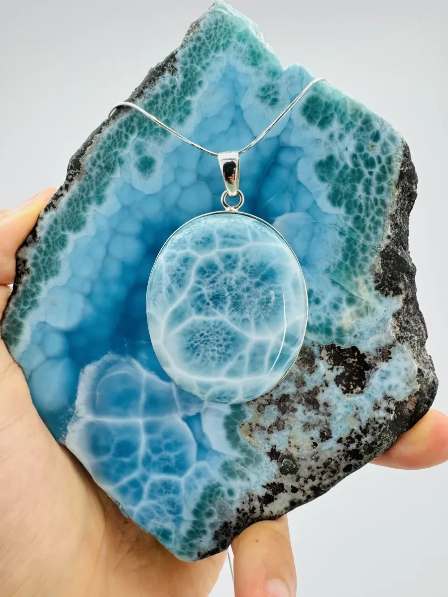 A Larimar geode-like specimen held for scale.